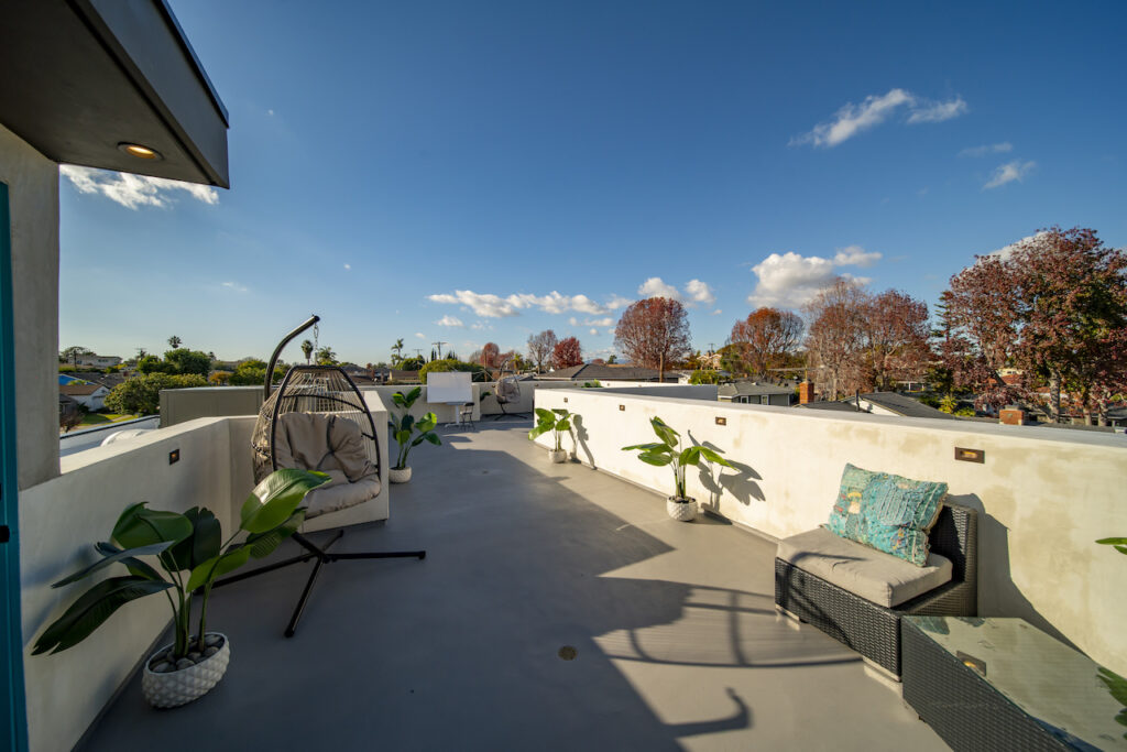 Spacious rooftop patio with plants and seating area
