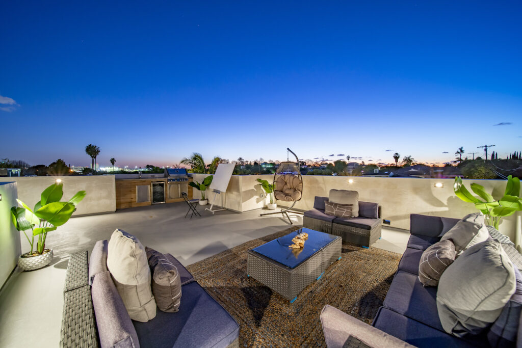 Rooftop patio with furniture at twilight.