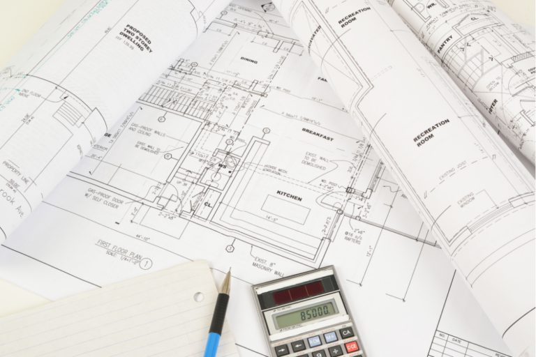 Architectural blueprints with calculator and pen.
