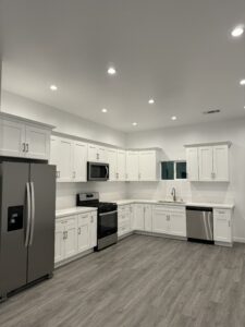 Modern kitchen with stainless steel appliances and white cabinets.