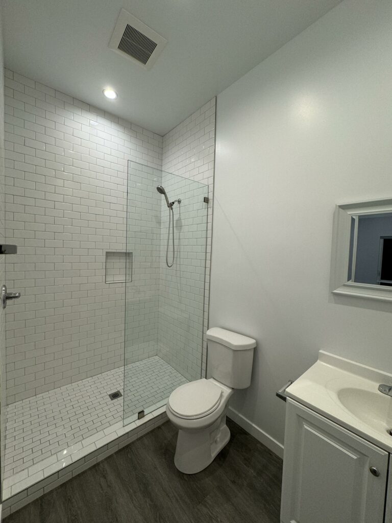Modern bathroom with white subway tiles and glass shower.
