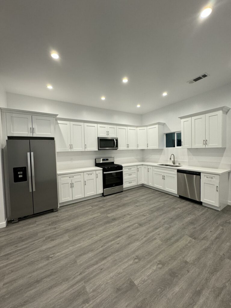 Modern kitchen, white cabinets, stainless steel appliances, recessed lighting