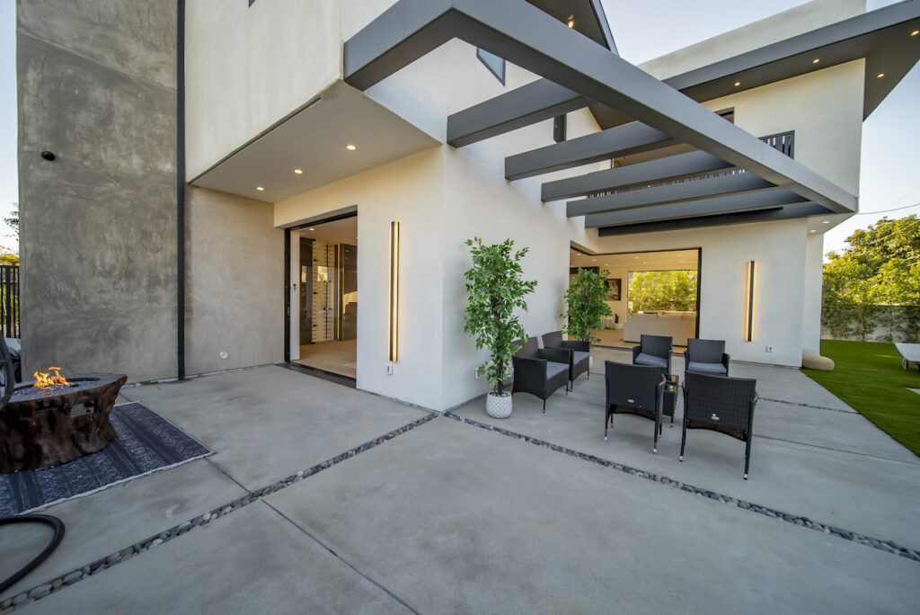 Modern home patio with outdoor furniture and fire pit.