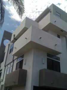 Modern architectural building exterior with palm tree.