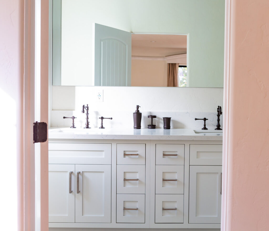 Modern white bathroom vanity with dual sinks and mirror.