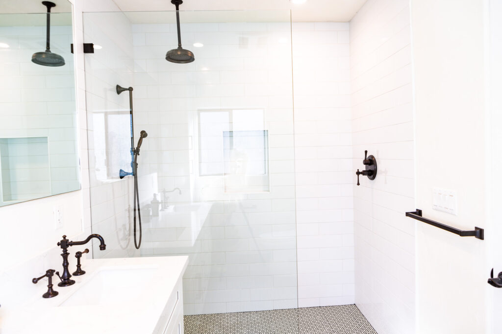 Modern white tiled bathroom with black fixtures.