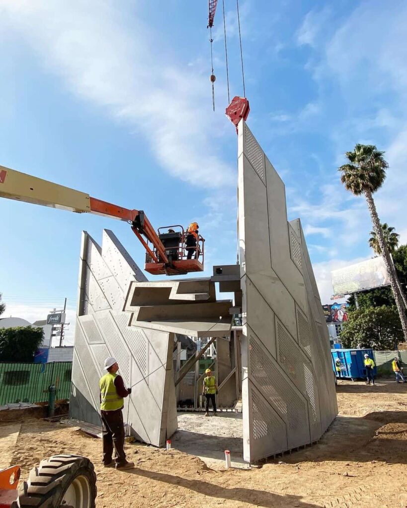 Construction workers assembling large concrete panels.