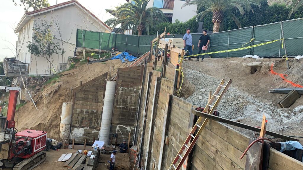 Construction site with workers and retaining wall project.