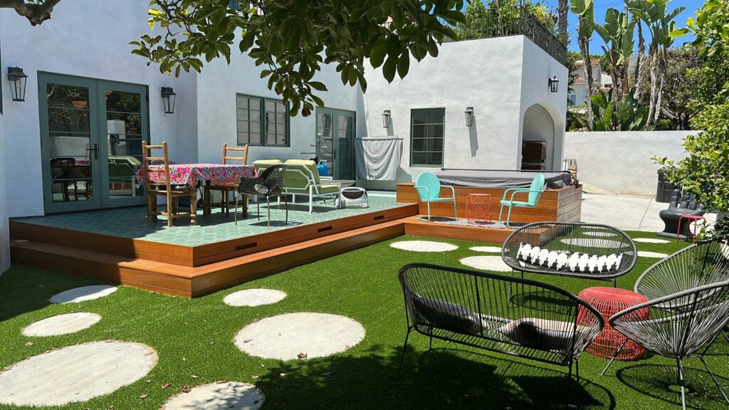 Sunny patio with colorful outdoor furniture and artificial grass.