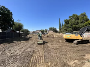 Construction site with excavator and soil compactor.