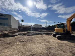 Construction site with excavator and clear blue sky.