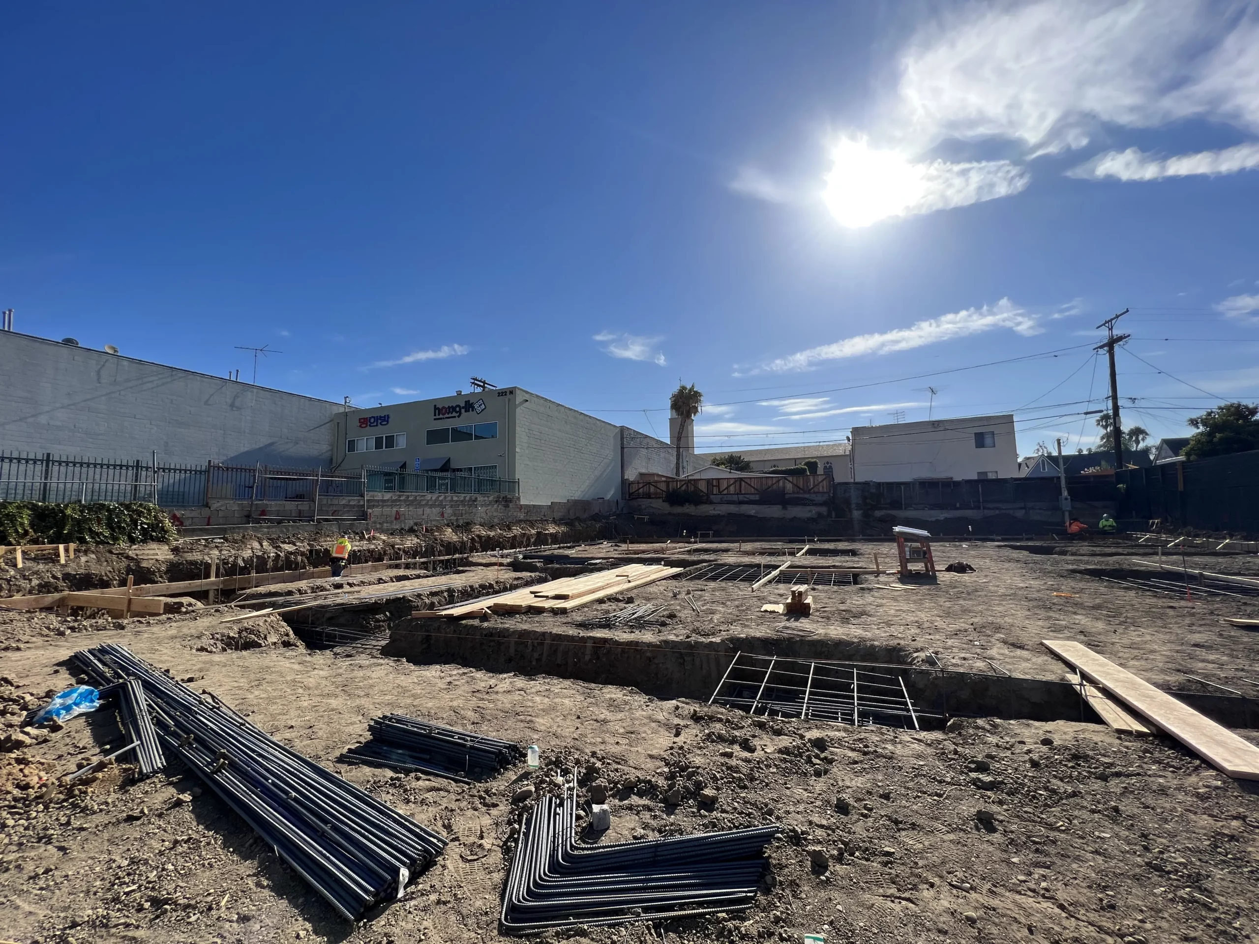 Construction site with foundational work and clear skies.