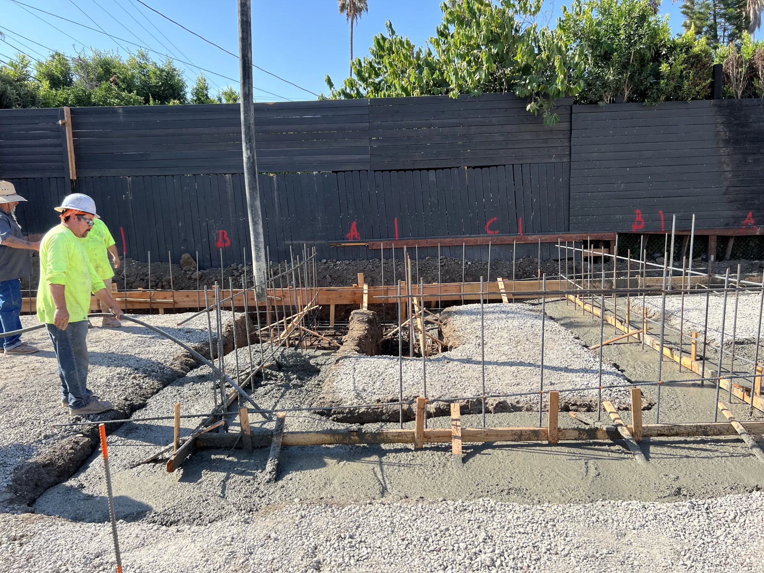 Construction workers at building foundation site.