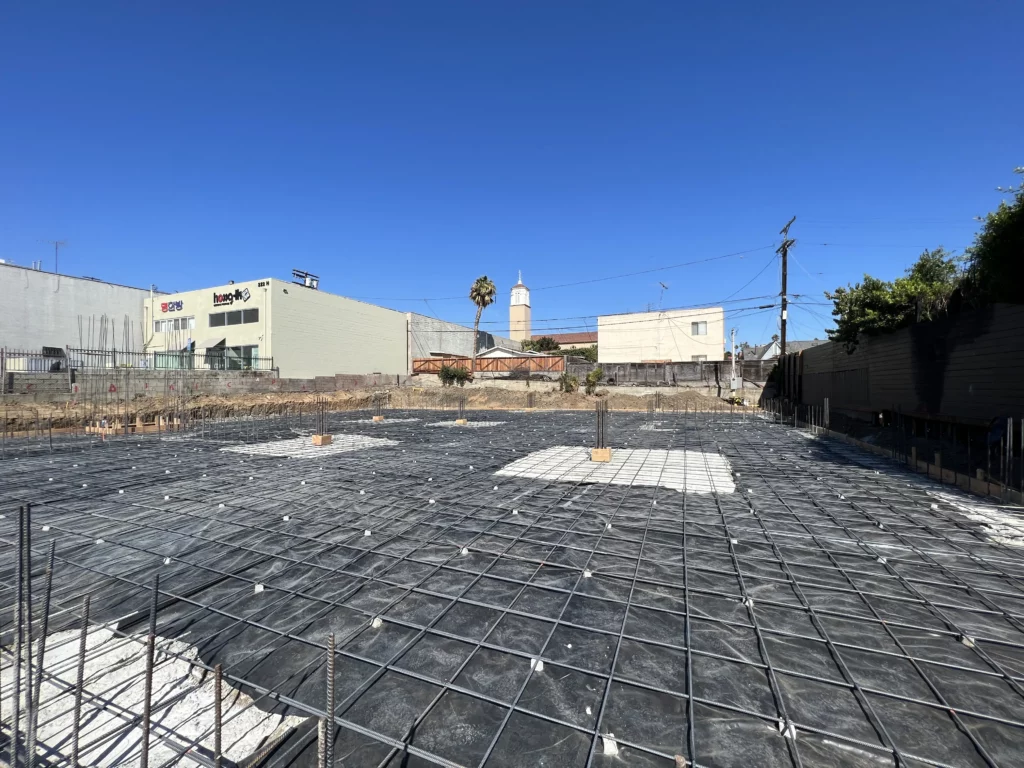 Construction site foundation with rebar grid and clear sky