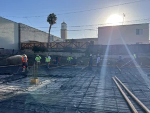 Construction workers laying foundation on sunny day