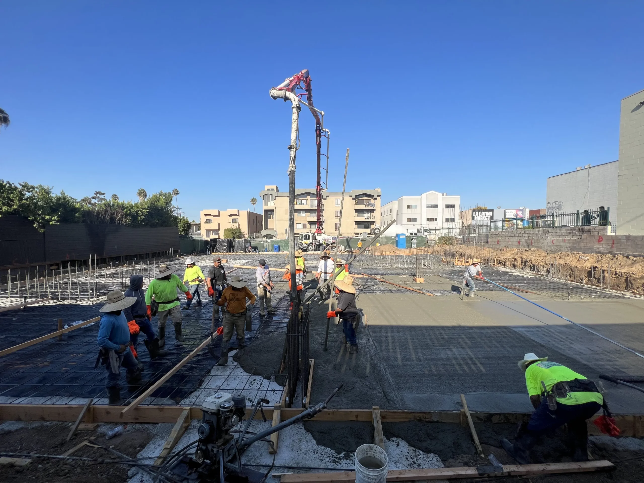 Construction workers pouring concrete at building site.