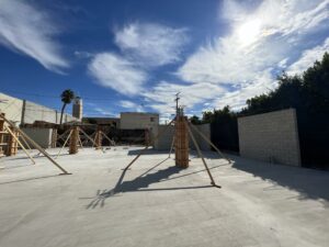 Sunny construction site with wooden frames and blue sky.