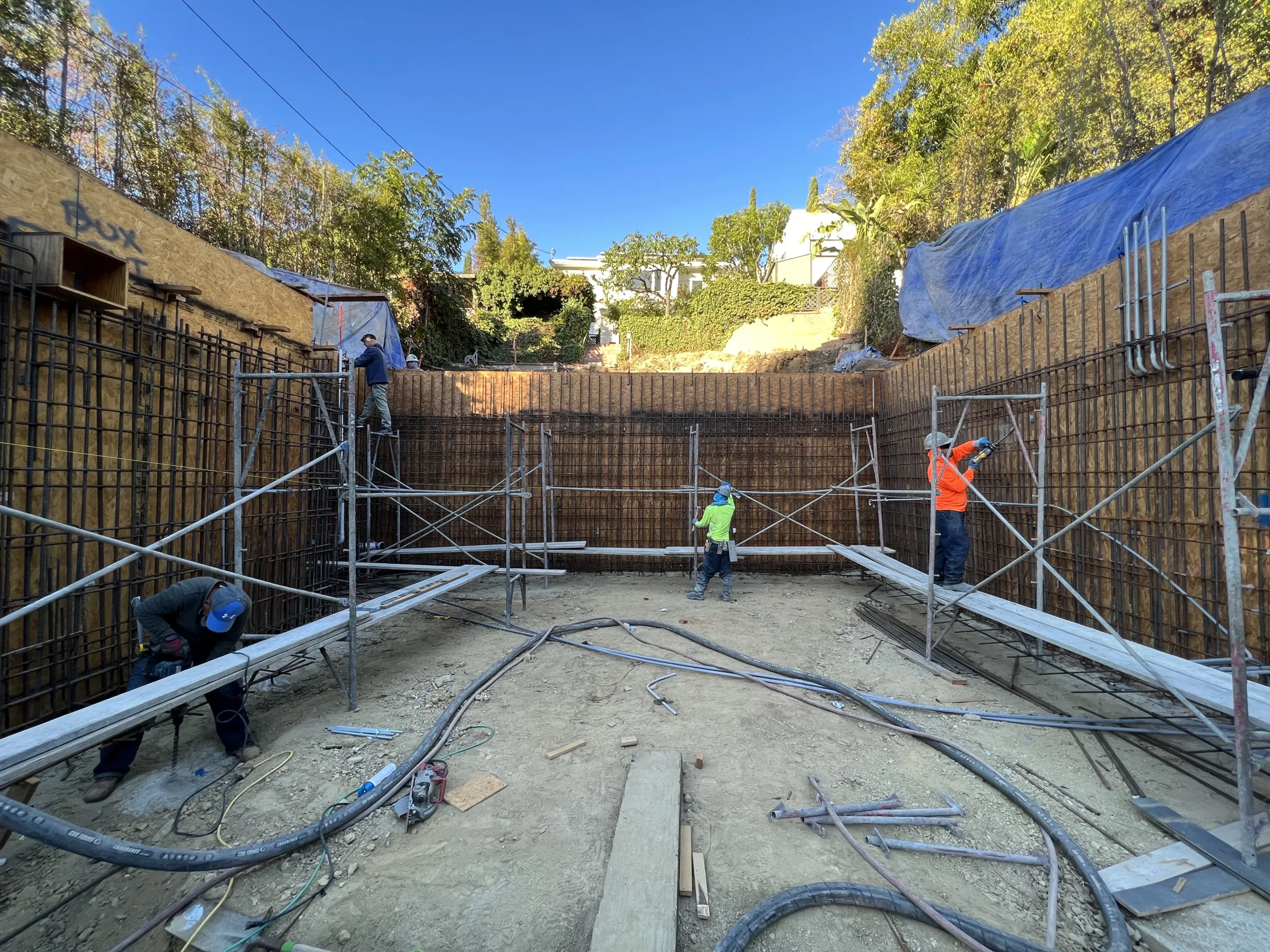 Construction workers assembling scaffolding at building site.