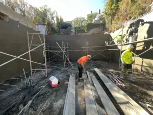 Workers at construction site with concrete formwork.