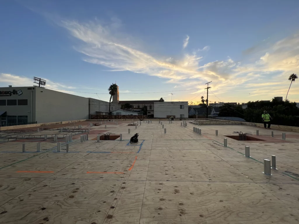 Construction roof with sunset and palm trees.