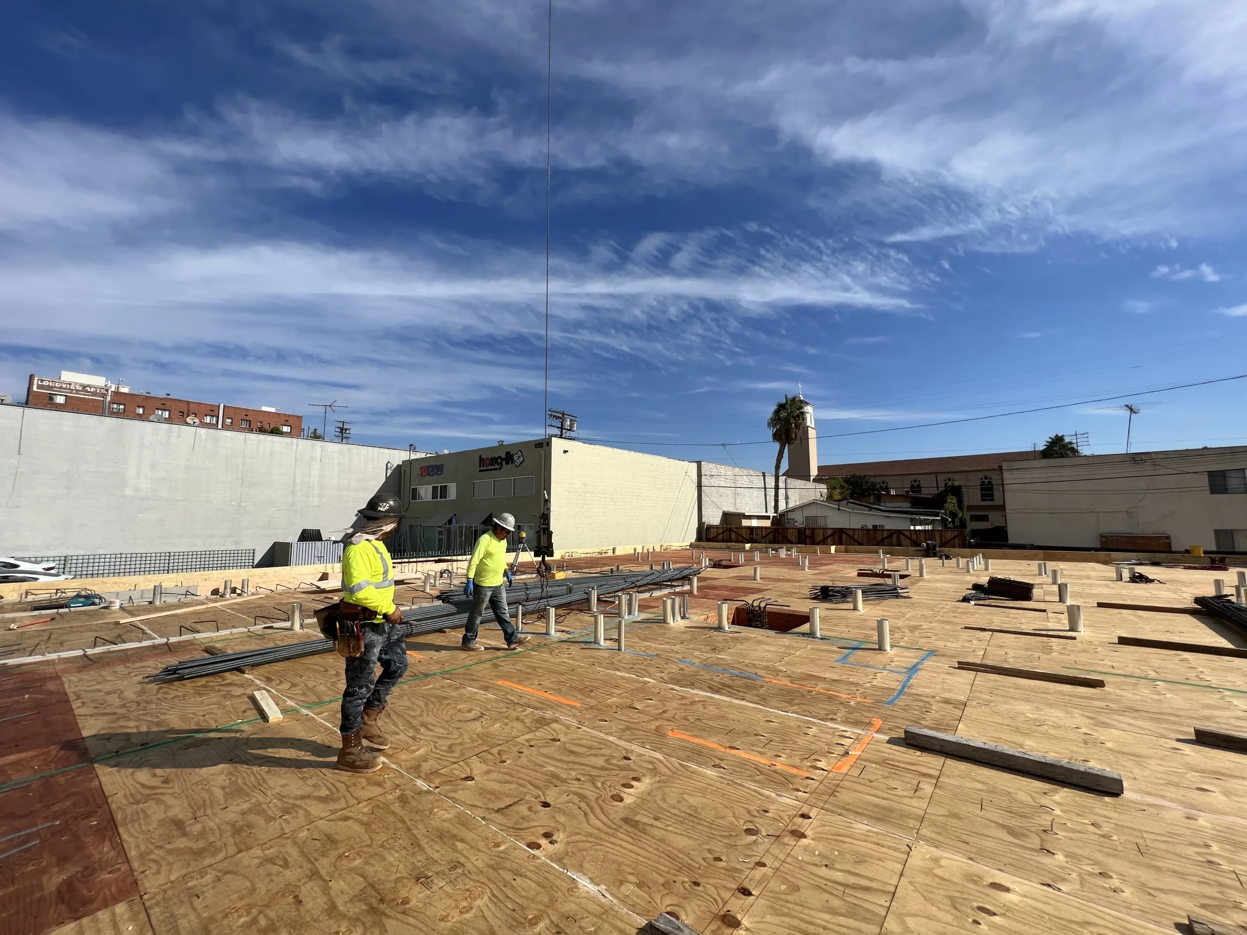 Construction workers on building site with clear sky.