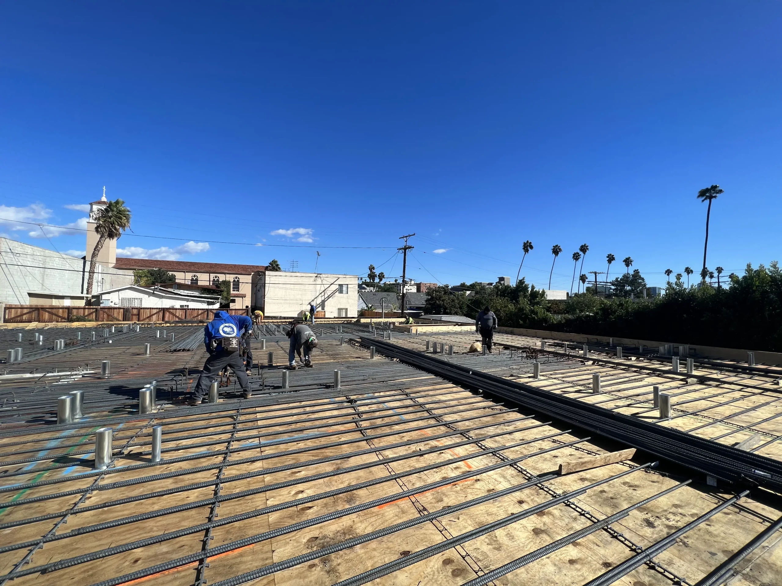 Construction workers installing rebar on building site.