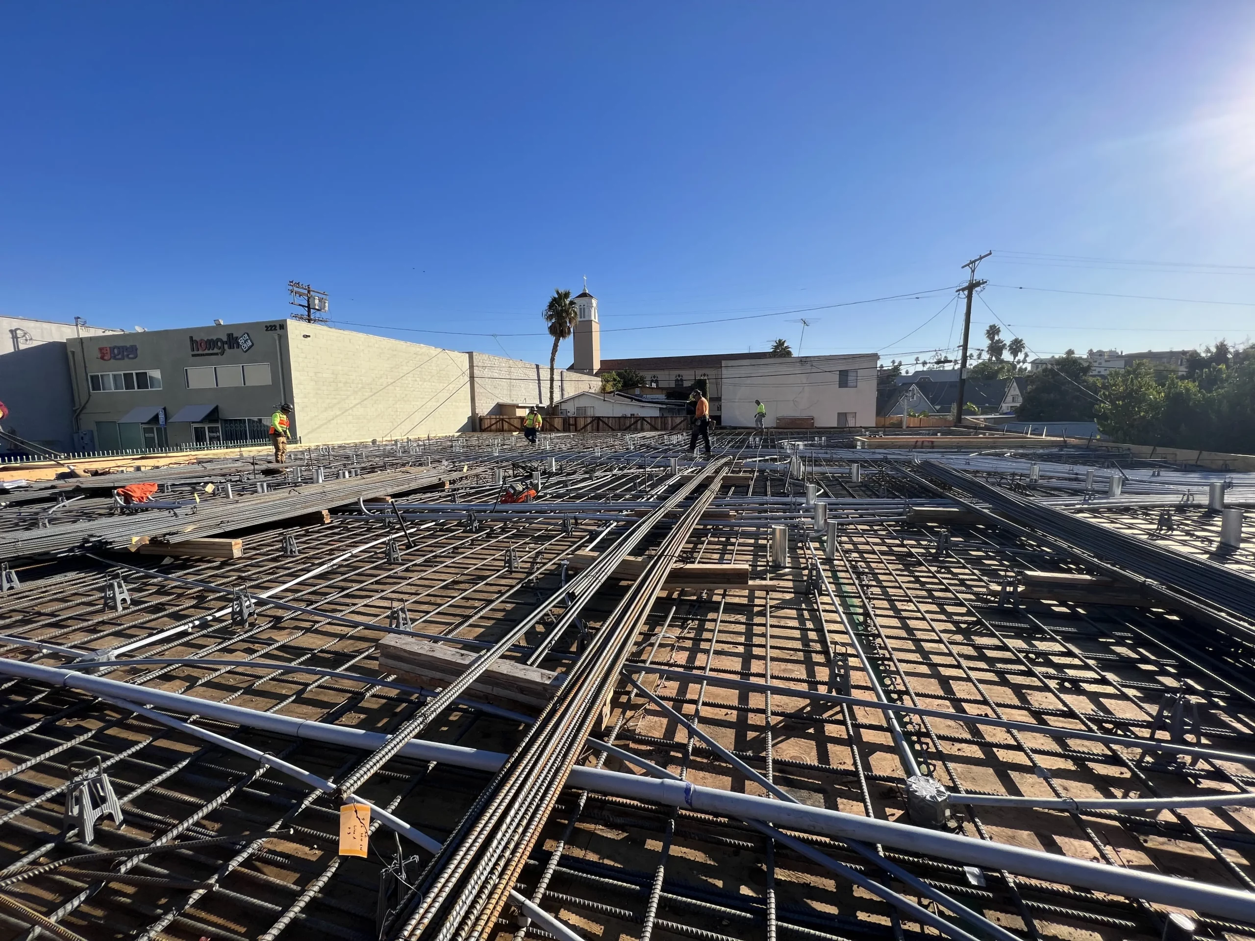 Construction site with rebar framework and workers.