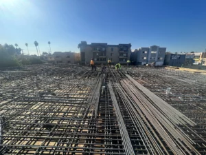 Construction workers laying rebar at building site.
