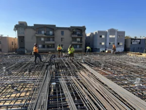 Construction workers installing rebar at building site.