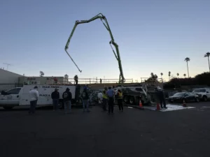 Concrete pump truck at construction site with workers.