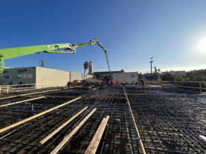 Construction site with crane and workers during early hours.