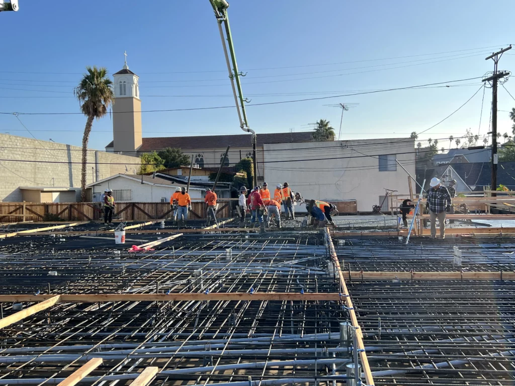 Construction workers laying foundation rebar at building site.