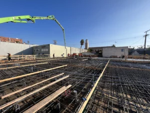 Construction workers laying foundation at building site.