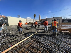 Construction workers pouring concrete at building site.