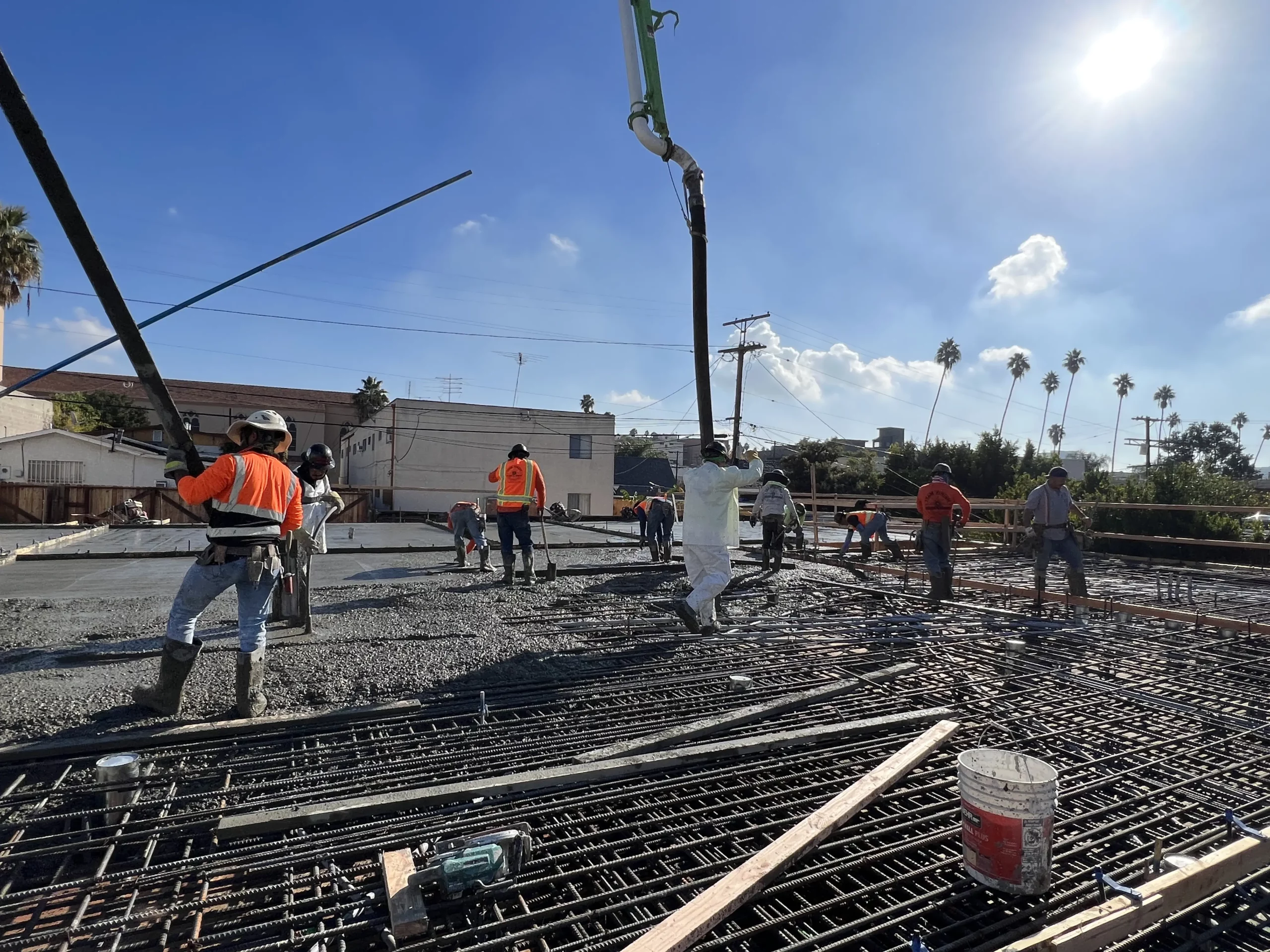 Construction workers pouring concrete at building site.
