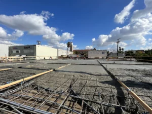 Construction site with rebar framework, cloudy sky.