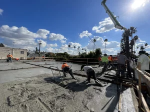 Workers pouring concrete at construction site.