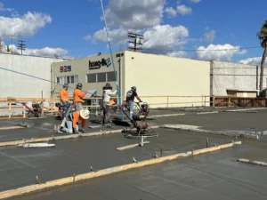 Workers smoothing concrete at construction site.