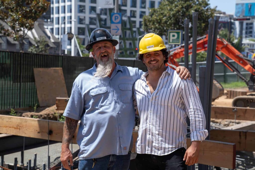 Two construction workers smiling at a building site