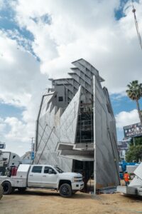 Modern building under construction with crane and truck.