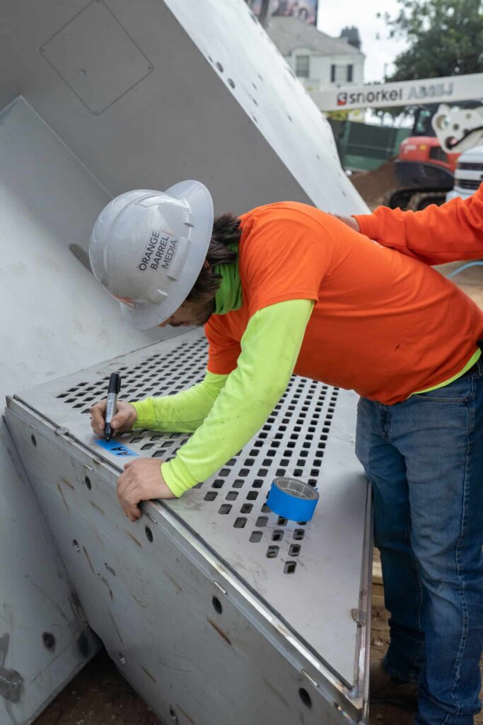 Worker marking equipment at construction site