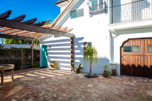 Charming house exterior with teal door and brick driveway
