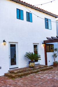 White stucco building with terracotta tiles and plants