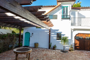 Charming courtyard with teal door and pergola.