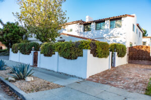 White Spanish-style house with landscaped front yard.