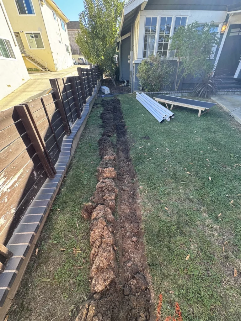 Trench dug in backyard for construction or repair.