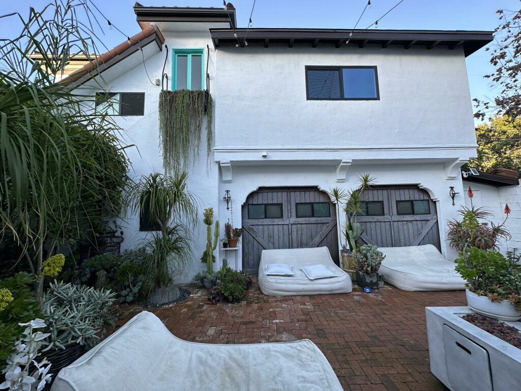 Cozy home exterior with garden and sitting area.