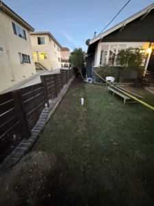 Residential backyard at dusk with wooden fence.
