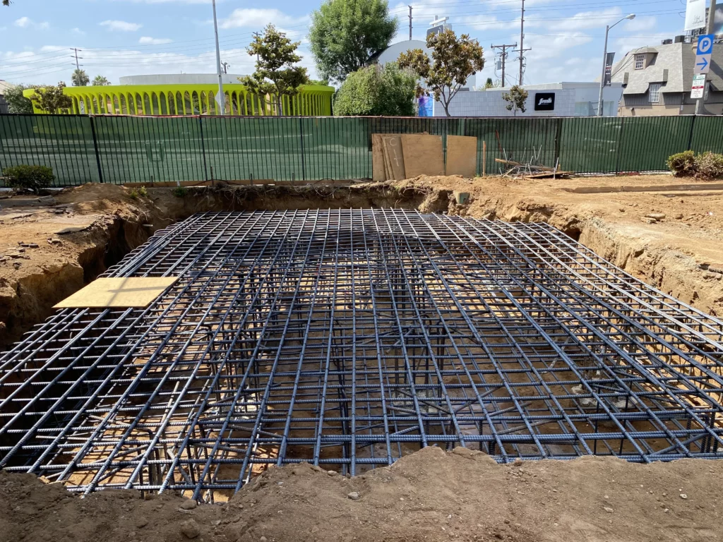 Construction site with steel rebar framework for concrete foundation.