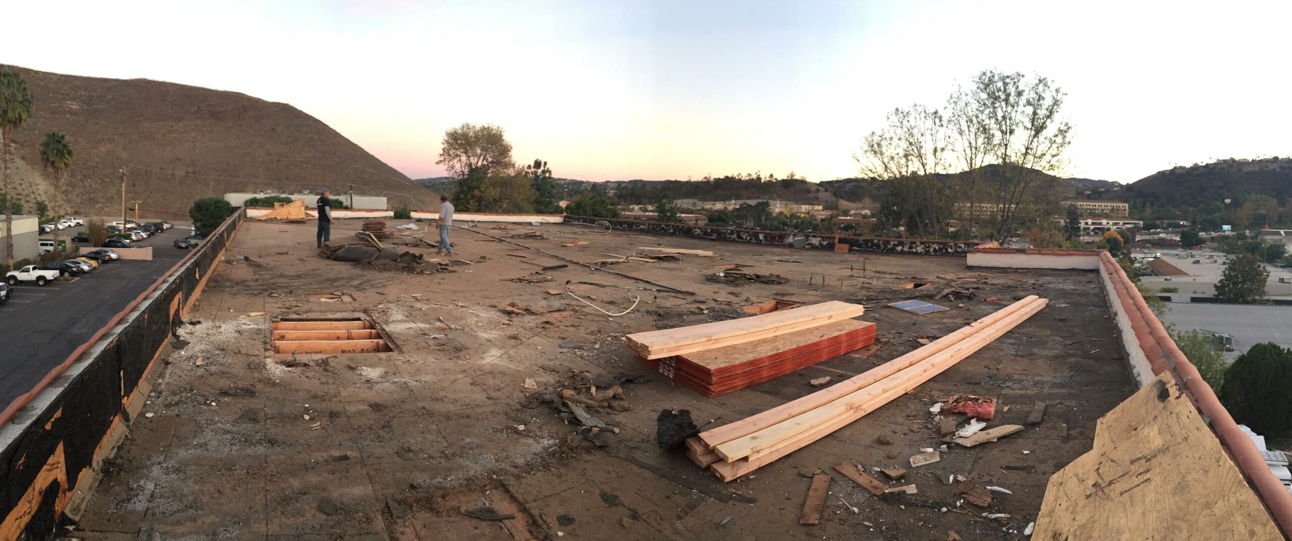 Panoramic view of a construction site on rooftop at dusk.
